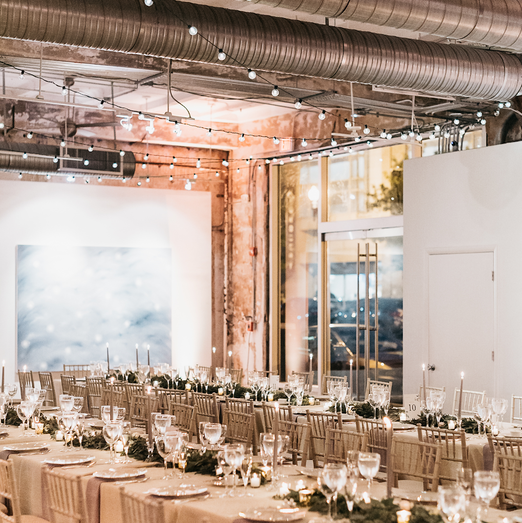 Art gallery wedding reception with warm, amber lighting.
